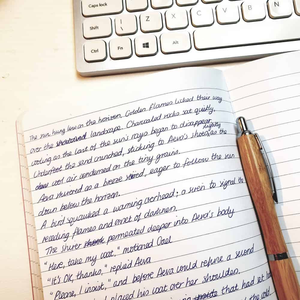 Fictional handwriting in a notebook with a pen sitting on top.